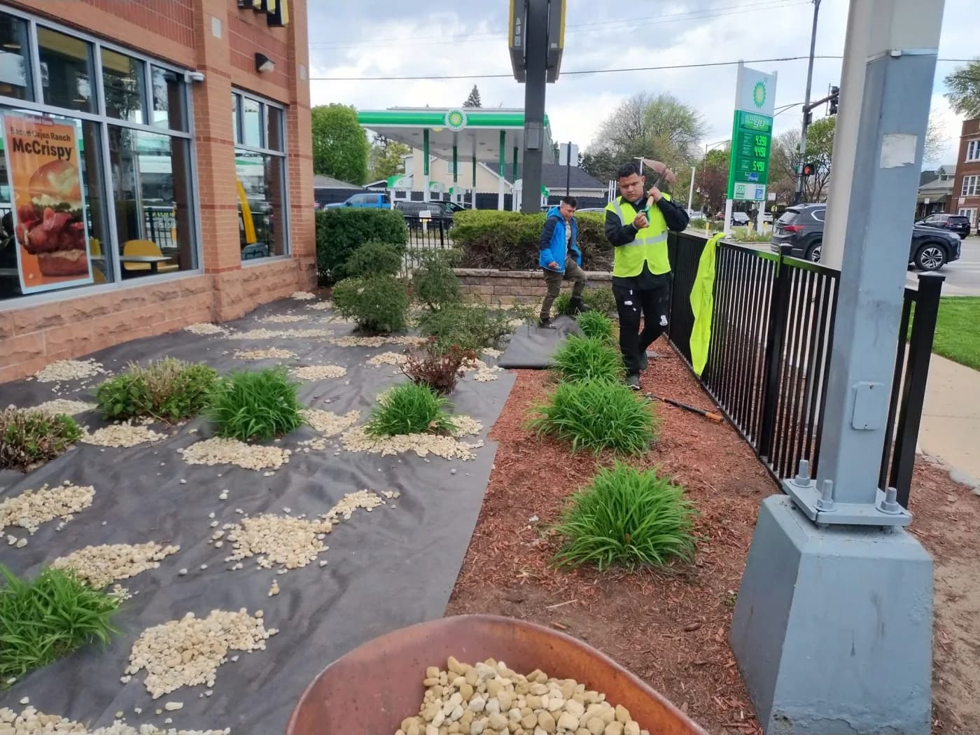 Crew setting plantings and decorative stone at a commercial site