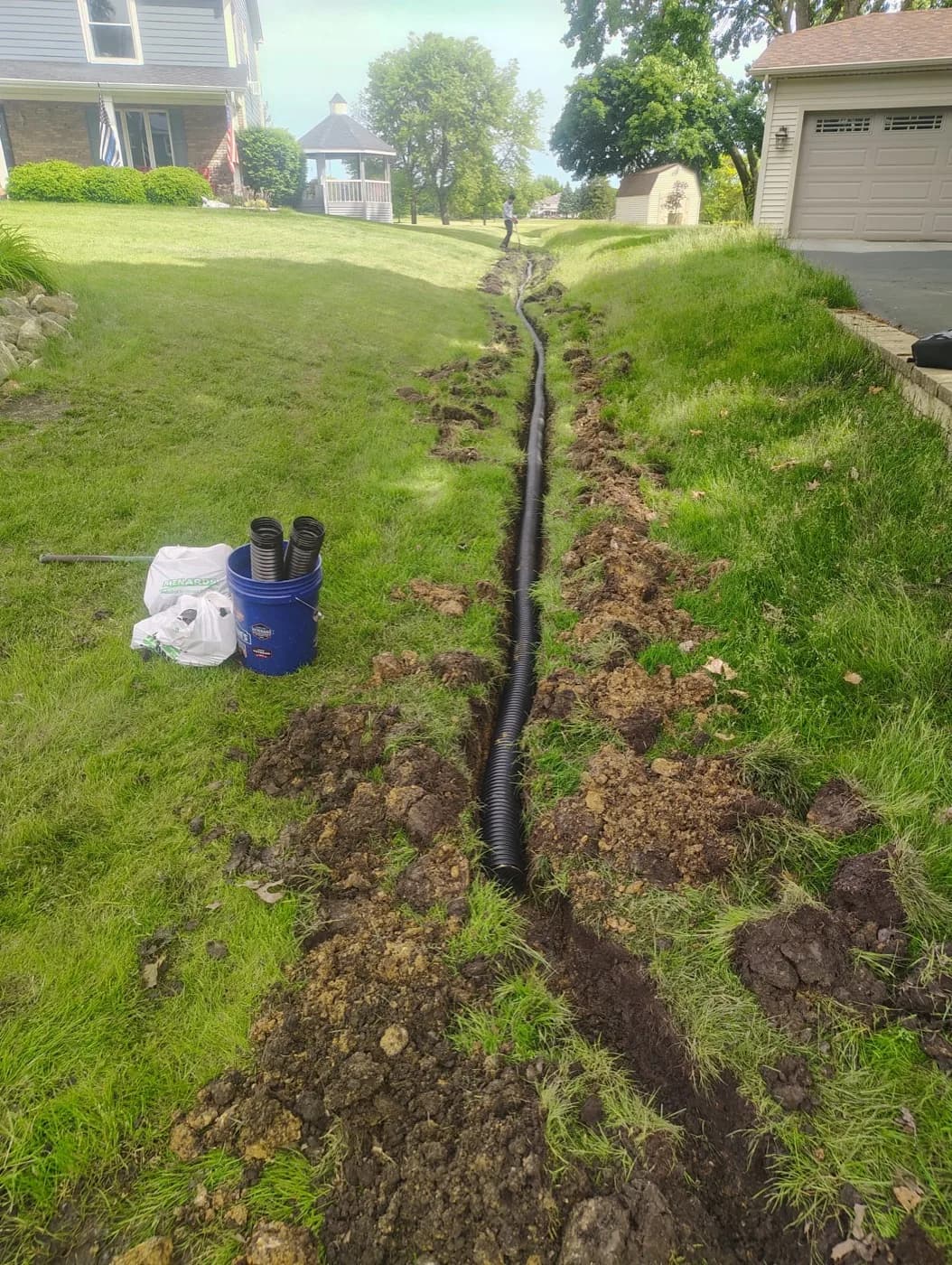 Corrugated drain pipe laid the length of a trench before backfill